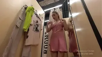 I try on clothes in fitting room with open curtain. People are passing and watching on me.