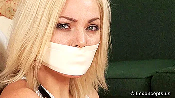 Hot Blonde tape gagged tied to a bed post