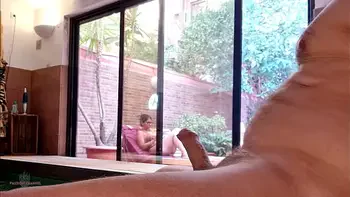 My stepson takes out his big cock on the terrace, gets excited looking at me behind the window and showing his erection to the neighbors. My nipples are very hard and I'm not wearing a bra.