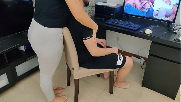 mature gives her stepson a handjob while watching porn