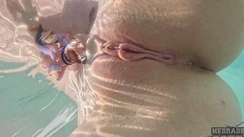Redhead teen with big natural tits plays with toys by the pool